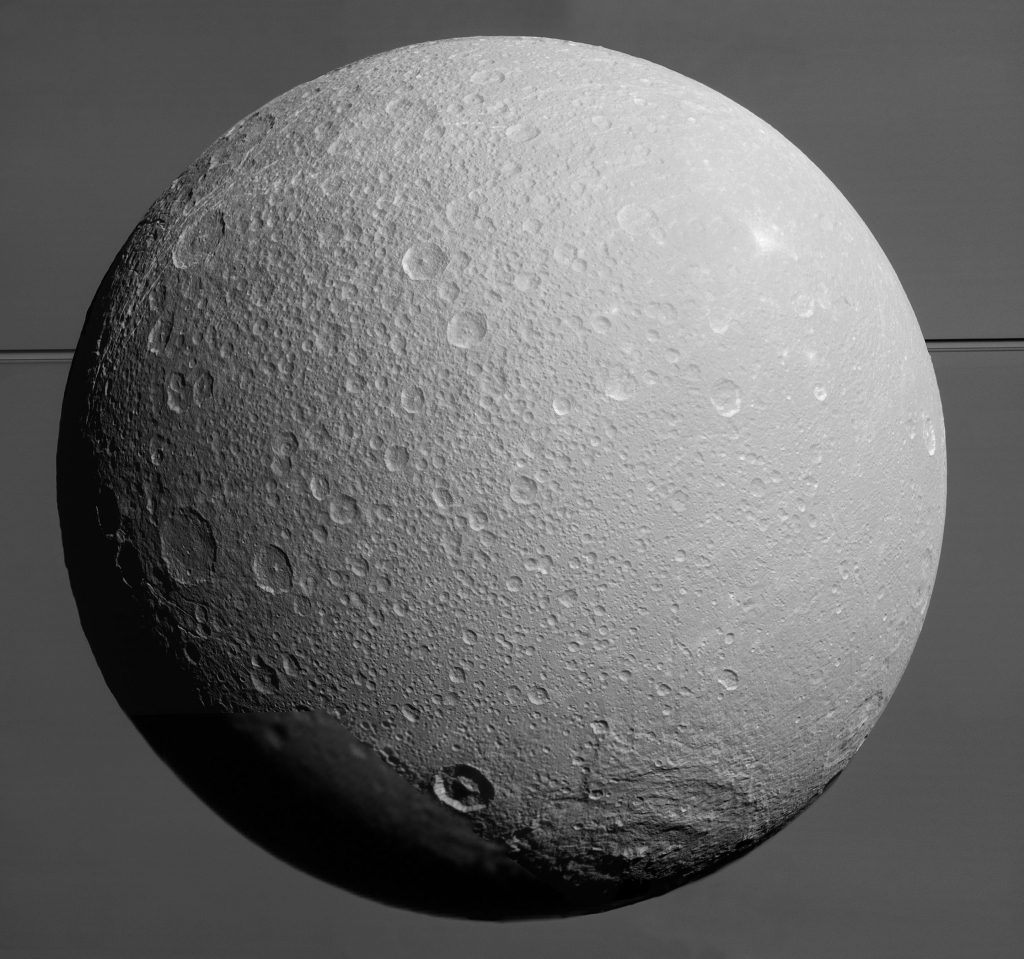 Saturn's Moon Dione silhouetted by Saturn's rings