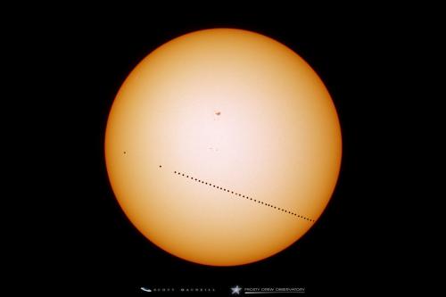 I captured this composite shot of the path Mercury took across the Sun during the Transit of Mercury. This is composite on 17 minute interval. The large gaps on the left are from a cloudy start. The large object at the top center is a sunspot 2542.
